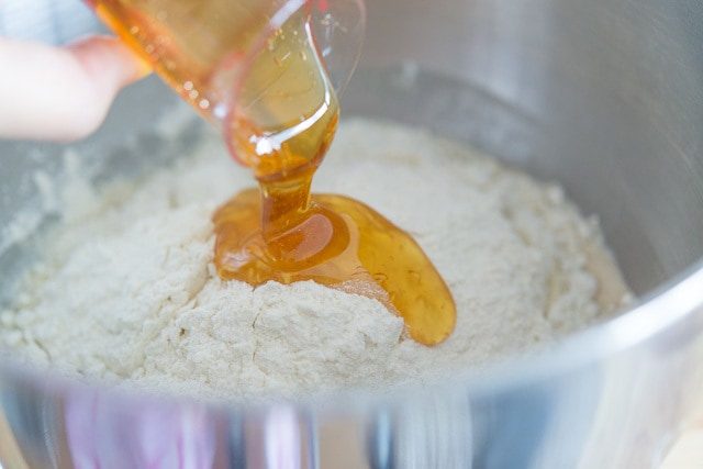 Pouring Honey Over Flour Mixture in Bowl