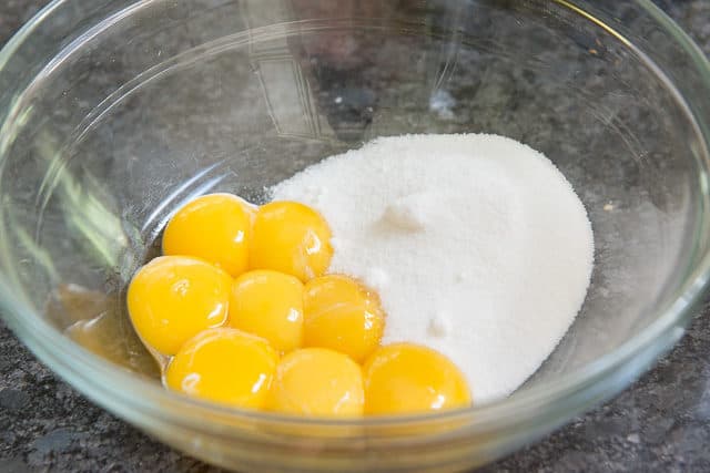 8 Egg Yolks and Granulated Sugar in Glass Bowl