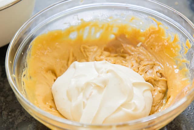 Sweetened Whipped Cream In A Bowl Of Cooked Egg Yolks, Sugar, and Peanut Butter