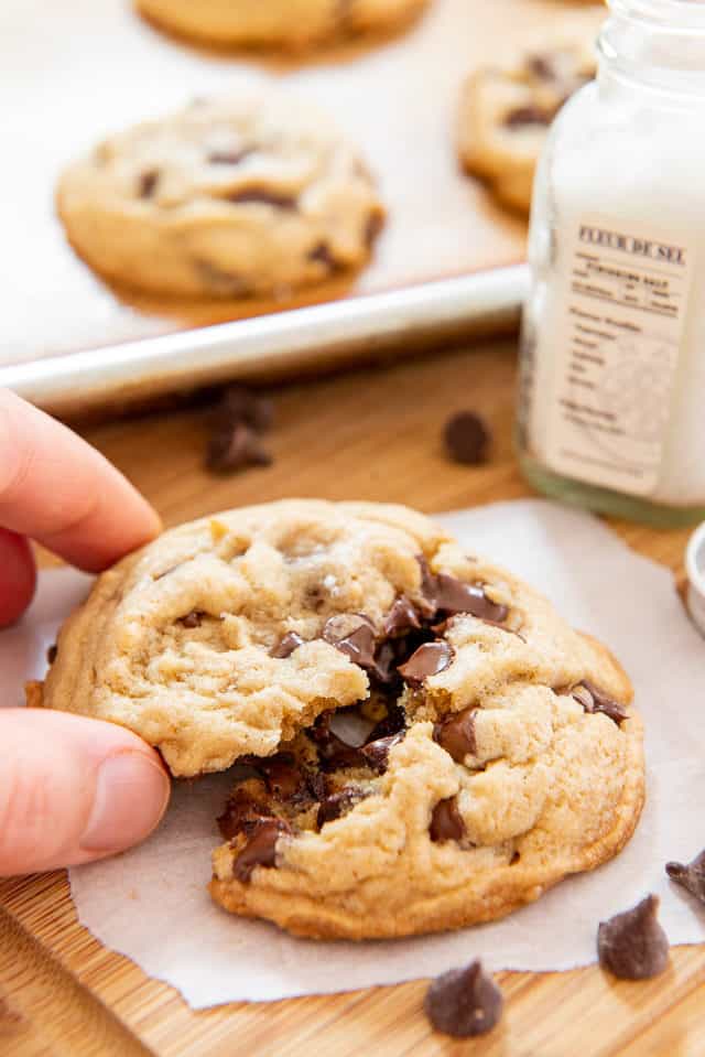 Splitting a Chocolate Chip Cookie with Hand to Show Warm melty Chocolate Inside