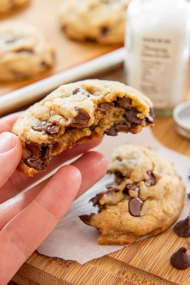 Simple Chocolate Chip Cookie Recipe - Shown with Gooey Center by hand Holding It Up