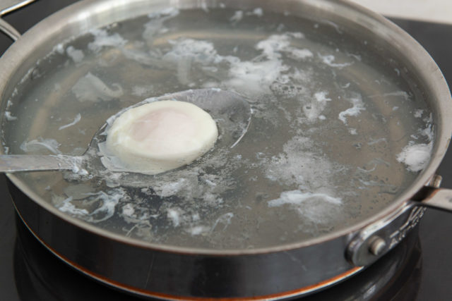 Retrieving a Poached Egg in Water with Slotted Spoon
