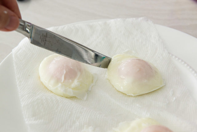 Poached Eggs Being Trimmed with Knife to Remove Whispy Egg White Threads