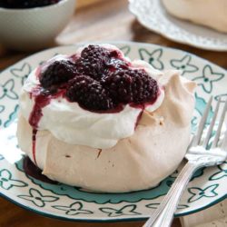 Pavlova On a Blue Plate with Cream and Blackberries On Top