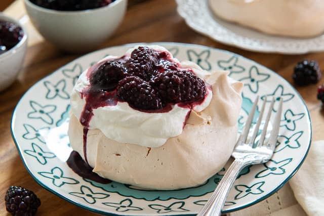 Pavlova Dessert - On a Blue Plate with Cream and Blackberries On Top
