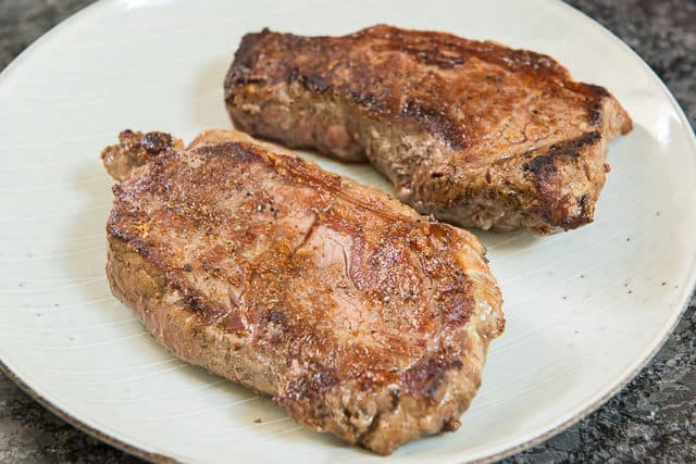 Strip Steaks Resting On Plate After Searing 