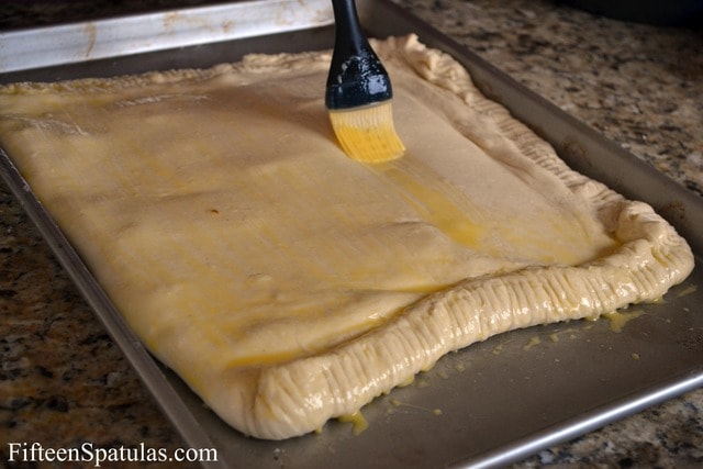Crimped and Filled Puff Pastry Square on Sheet Pan, Brushed with Egg Wash on Top