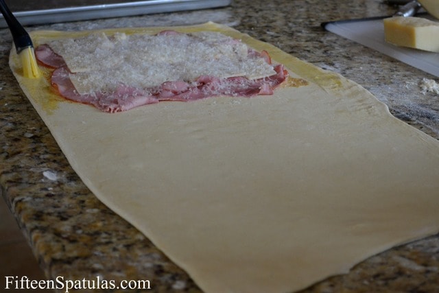 Fully Rolled Out Puff Pastry with Ham Slices and Sheet, Brushed with Egg Wash on the Edges