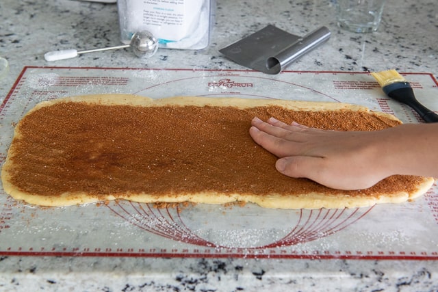 Pressing the Brown Sugar Cinnamon Filling into the Sweet Dough before Rolling