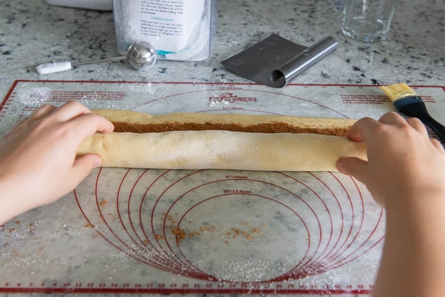 Rolling the Cinnamon Roll Dough Log up into a Spiral Shape