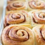 Cinnamon Roll Recipe - In a Tray Golden Brown and Puffy Before Orange Butter Icing is Added