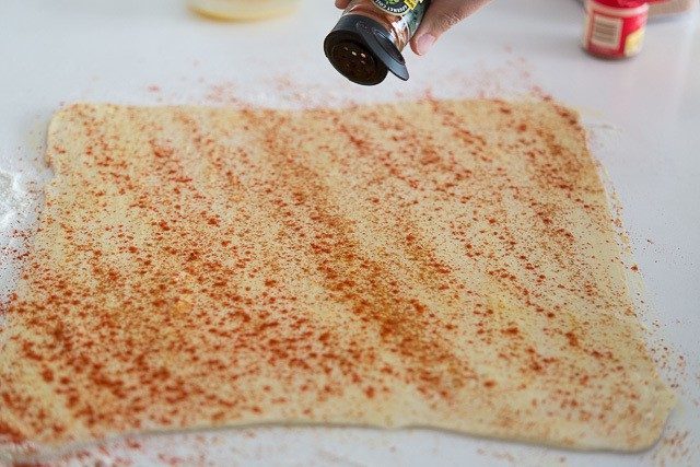 Sprinkling puff pastry dough with Cayenne Pepper