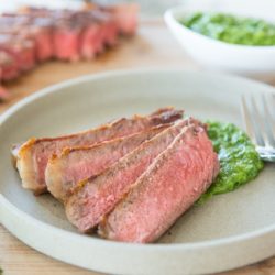 Slices of Steak on a Plate with Chimichurri Sauce