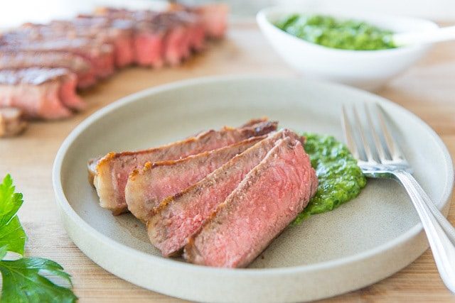 Slices of Seared Steak on Plate with Chimichurri
