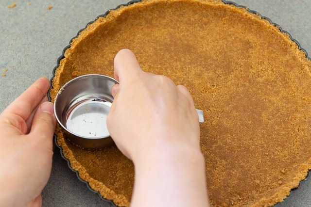 How to Make Graham Cracker Crust - Press in Firmly with Measuring Cup