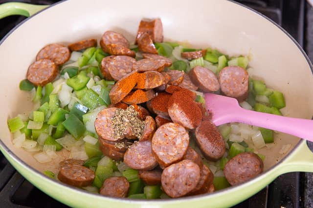 Andouille Sausage Slices and Spices Added to Vegetables in Braiser