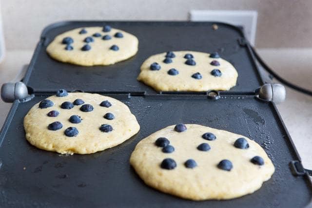 Blueberry Cornmeal Pancakes - On Griddle in 4 circles