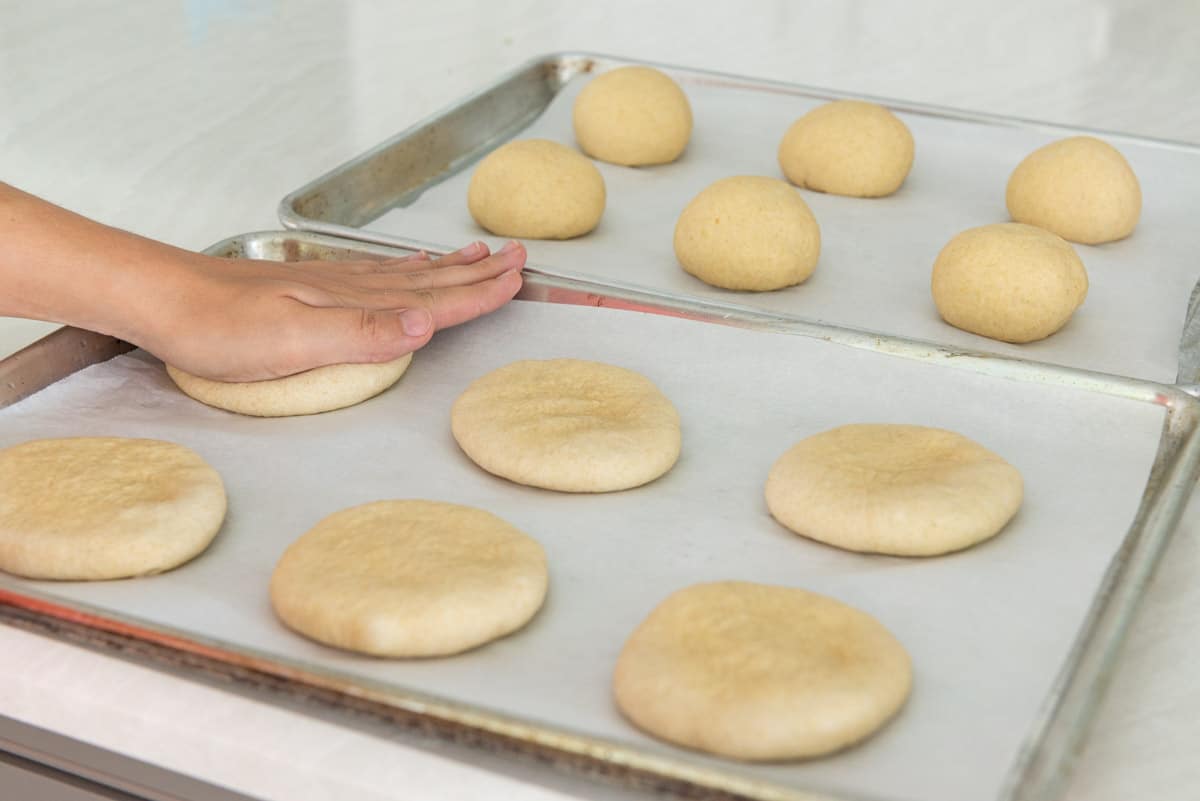 Flattening the Whole Wheat Hamburger buns with Palm of Hand