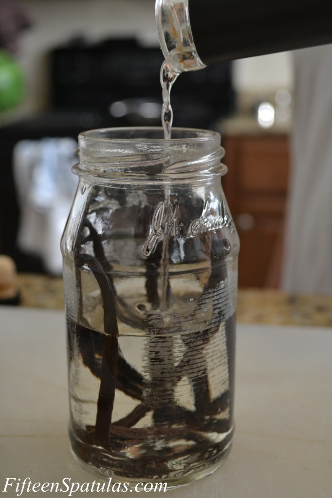 Pouring Vodka Into a Glass Jar with Vanilla Beans