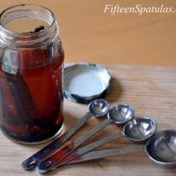How to Make Vanilla Extract - Steeped Vanilla Beans in Glass Jar with Measuring Spoons on Board