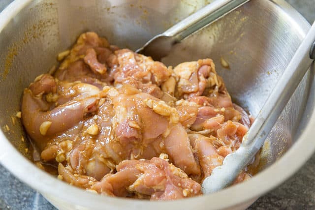 Tossing Boneless Skinless Chicken Thighs in Marinade In bowl