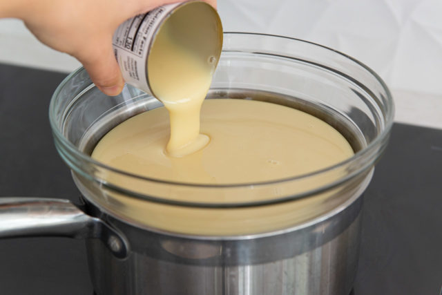 Pouring Sweetened Condensed Milk Into Double Boiler for Dulce De Leche