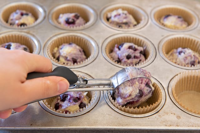 Scooping Blueberry Muffin Batter into Muffin Liners