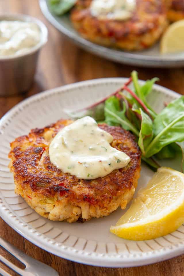 Crab Cakes - Served on Plates with Dollop of Tartar Sauce and Lemon Wedge