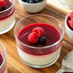 Panna Cotta In Glasses with Fresh Berries On Top of Raspberry Gelee