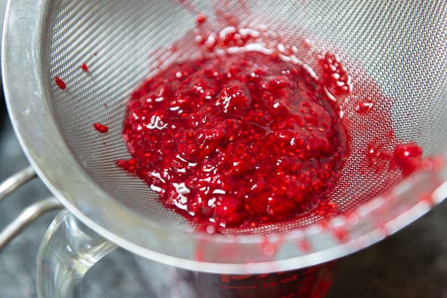 Straining the Raspberry Seeds with a Fine Mesh Strainer