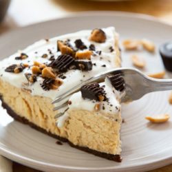 Peanut Butter Pie Sliced and Served on Gray Plate with Fork Cutting Through