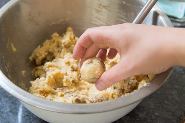 Mashed Potato Ball in Hand Over Mixing Bowl