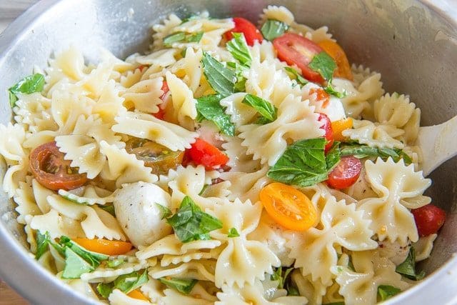 Caprese Pasta Salad Recipe - In mixing bowl with Bowtie pasta, tomatoes, mozzarella, and basil