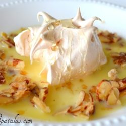 Ile Flottante - Meringue Piece in Creme Anglaise Pool in White Bowl with Almond Clusters Around