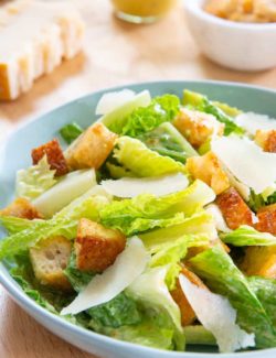 Caesar Salad - In a Blue Bowl with Croutons and Parmesan Shavings