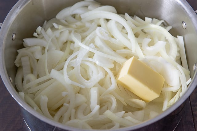 Sliced yellow onions and butter in big metal Pot