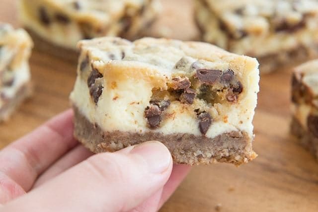 Cookie Dough Cheesecake Bars - Side View Held by Hand Seeing Layers