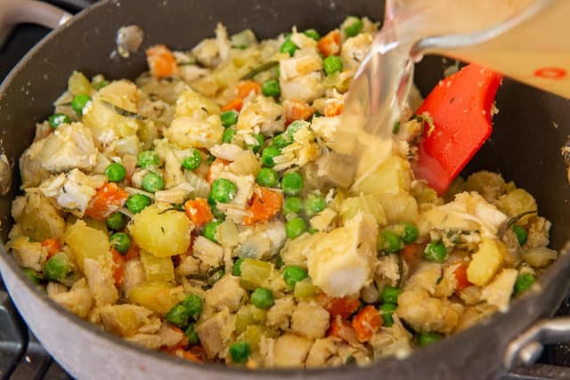 Pouring Chicken Stock Into Vegetable Mixture In Pan