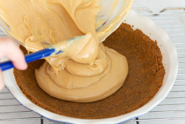 Pouring Dulce de Leche Into Gingersnap Crust for the Best Banoffee Pie Recipe