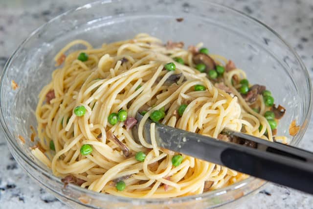 Spaghetti Carbonara with Peas - In Glass Bowl with Tongs Tossing