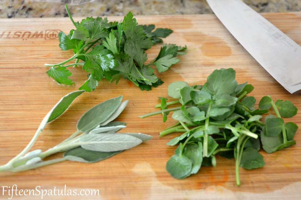 Fresh parsley, sage, and watercress on cutting board