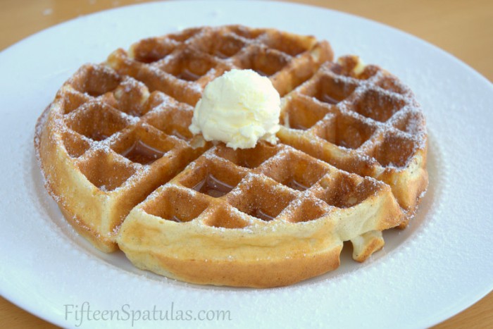 Crispy Whole Waffle on Plate with Butter, Maple Syrup, and Powdered Sugar