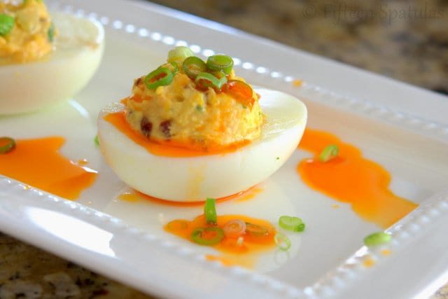 Asian Deviled Eggs on White Platter with Chile oil and Scallions