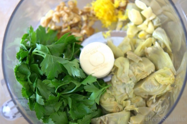 Artichoke Pesto Ingredients like Artichoke Hearts, Parsley, Walnuts, Lemon, and Garlic in Food Processor