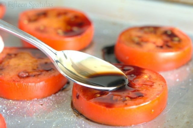 Spooning balsamic on top of tomatoes before roasting