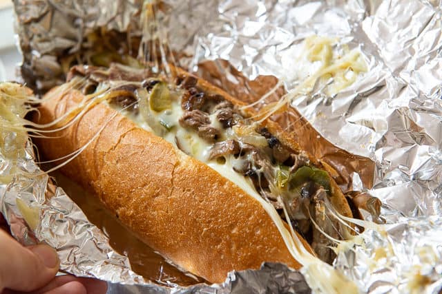 Cheesesteak Hoagie with Gooey Provolone Cheese Stretching to Foil