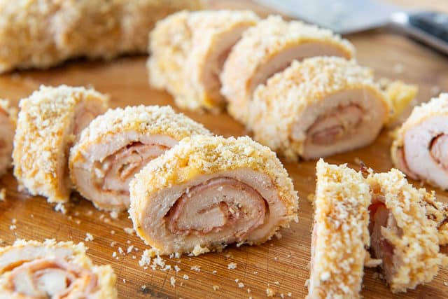 Slices of the Best Chicken Cordon Bleu Recipe on a wooden board with knife
