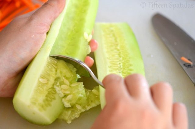 Scooping Seeds Out of Halved Cucumbers with Spoon