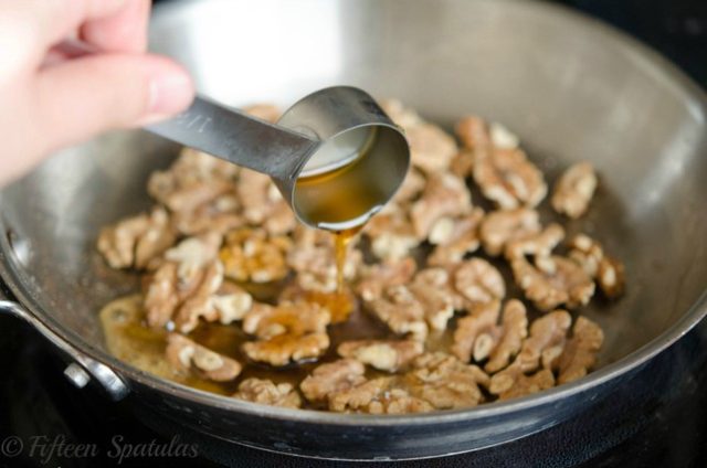 maple syrup glazing walnuts and bubbling in pan for candied process