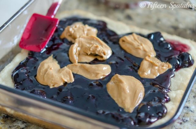 swirling peanut butter dollops with jelly on shortbread bar base